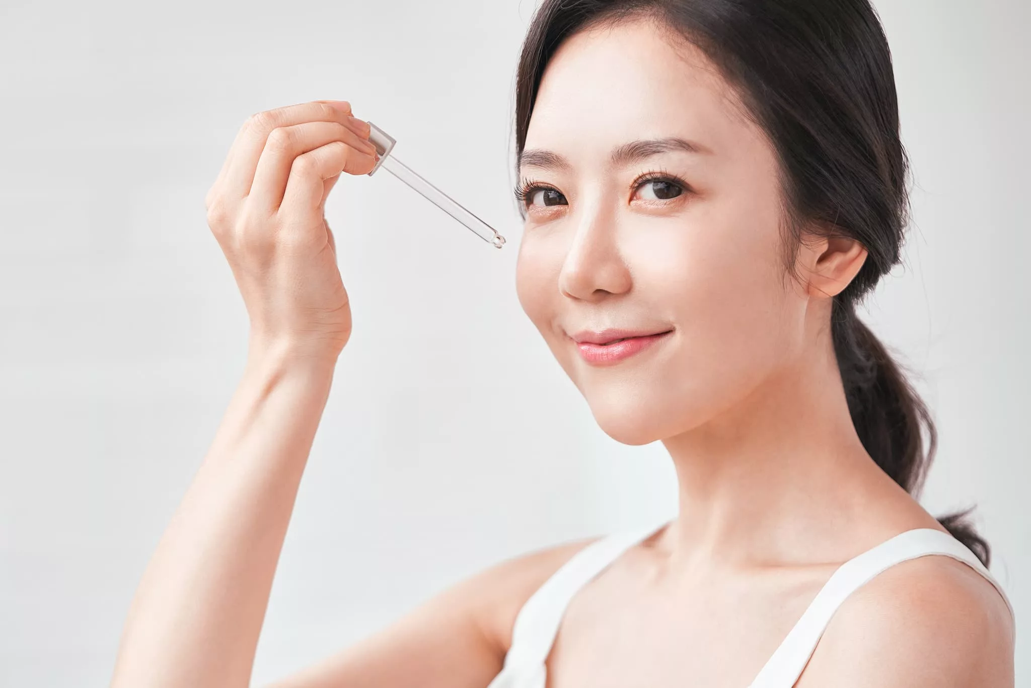 用滴管塗抹護膚精華的女性